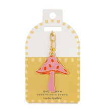 Load image into Gallery viewer, A pink and orange mushroom-shaped bag charm with gold-tone metal details, attached to a white and yellow display card labeled 'Lucky feather'.