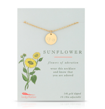 Load image into Gallery viewer, A gold necklace with a round sunflower-themed pendant displayed on a light blue card. The card features a sunflower illustration and text that reads 'SUNFLOWER' and 'flowers of adoration' with the brand name 'Lucky Feather' at the bottom left.