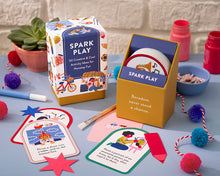 Load image into Gallery viewer, spark play card deck in box, alongside an open box of cards tht states 'boredom never stood a chance' and several cards strewn about on a blue table with various craft supplies