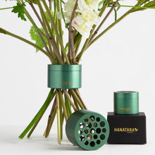 Load image into Gallery viewer, hanataba original bouquet twister in ivy green shown in use with several stems of flowers alongside both sizes of product included and the package they come in, a black box with gold foil hanataba logo