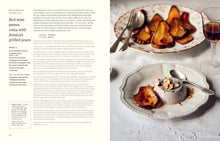 Load image into Gallery viewer, A two-page spread from a cookbook featuring a recipe for red wine panna cotta with grilled pears. The left page contains the recipe text, and the right page shows a plated dessert with caramel sauce and nuts, along with a glass of red wine in the background.
