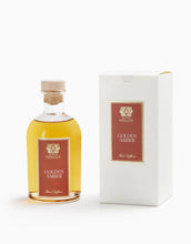 Load image into Gallery viewer, A bottle of Antica Farmacista Golden Amber oil diffuser next to its white presentation box, both featuring a dark red label with gold lettering and crest, on a clean white background.
