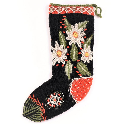 100% wool handmade knit stocking made in Nepal by new Horizons. Features Edleweiss white flowers on a black background with sage green leaves and a festive top lining 
