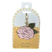 Load image into Gallery viewer, A pink hand-painted enamel bag charm shaped like a rose with green leaves and a gold-tone clasp, attached to a white and yellow display card labeled 'Lucky Feather'. 
