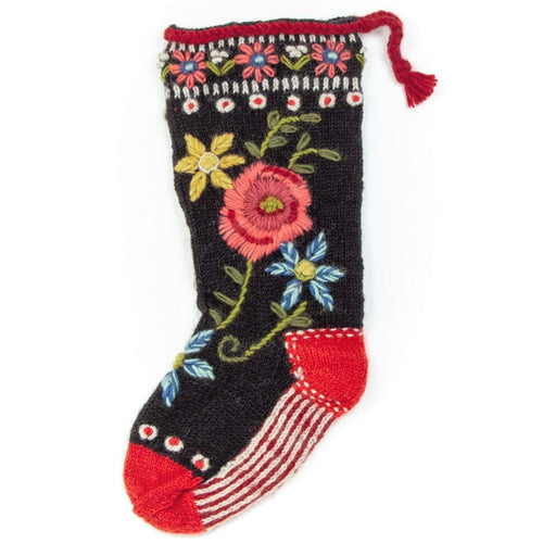 100% handmade wool knit stocking made in Nepal by New Horizons. Features a black background with floral knitting on the top with a big pink rose with a blue and yellow flower with vines.