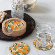 Load image into Gallery viewer, Set of floral coasters with a glass on a white surface
