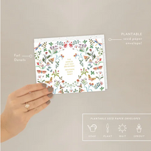 Load image into Gallery viewer, Hand holding a plantable seed paper envelope and card with floral design on a beige background
