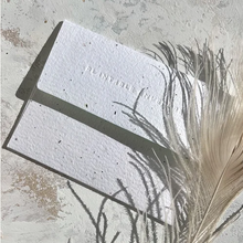 Load image into Gallery viewer, White textured envelope with 'Plantable Envelope' text, placed on a textured surface with a feather.
