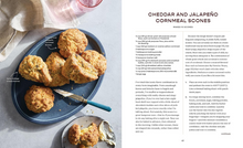 Load image into Gallery viewer, A printed recipe spread page for cheddar and jalapeño cornmeal scones, showing a close-up photo of prepared scones on a blue plate at the top left, recipe text on the left column, and title and instructions on the right column.

