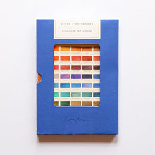 Load image into Gallery viewer, A blue notebook cover or notebook package with a rectangular window showing a grid of many color chips, photographed on a plain white background.
