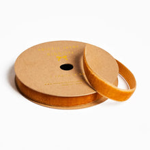 Load image into Gallery viewer, Spool of orange velvet ribbon on a white background
