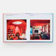 Load image into Gallery viewer, Open book showing two interior design images with red walls and colorful decor.

