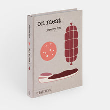Load image into Gallery viewer, The book 'On Meat' by Jeremy Fox, published by Phaidon, shown standing upright at a slight angle. The book cover has a textured light beige linen-like background with minimalist illustrations of a sausage, a slice of meat, and a round food piece in muted red, pink, and dark brown tones.
