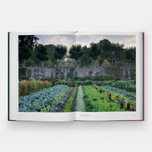 Load image into Gallery viewer, Open book showing a garden scene with rows of plants and trees in the background.
